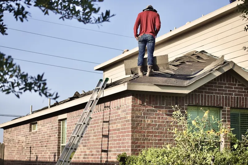 Professional roofer working on a residential roof in Higley Village